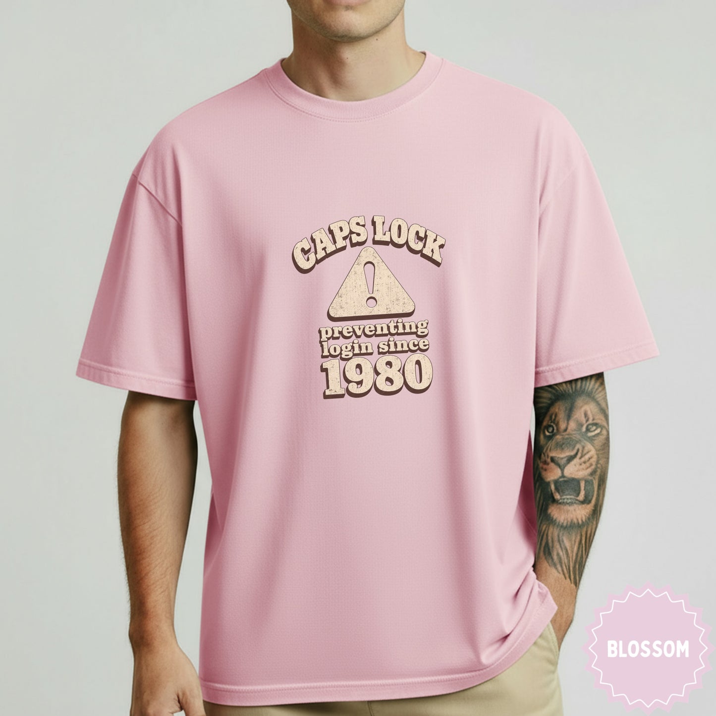 Pink t-shirt with "Caps Lock preventing login since 1980" text and exclamation point warning symbol.